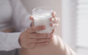 怀孕妇女拿着一杯牛奶