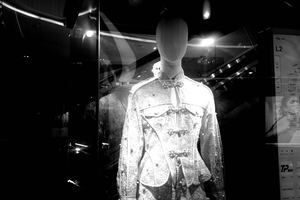 一个穿着夹克和衬衫的模特儿在商店橱窗里。