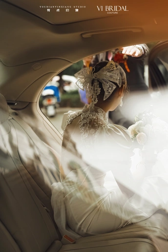 一位穿着白色婚纱的女人坐在汽车里