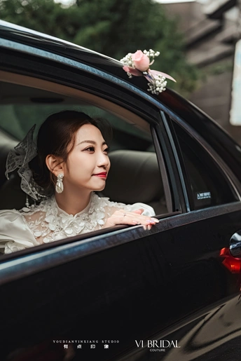 一位女性坐在汽车里 正在通过窗户向外看。