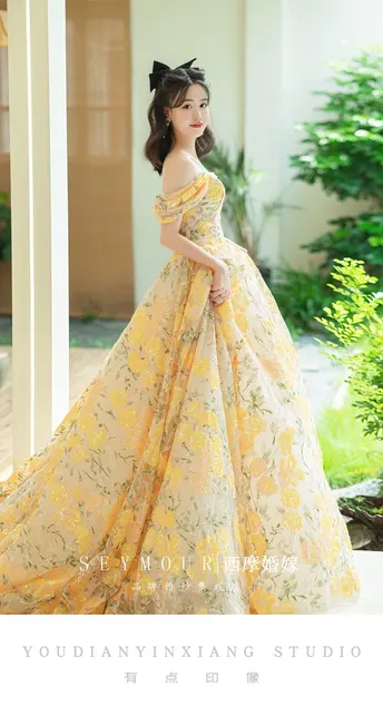 新洋娃娃穿着一件带有拖尾的黄色婚礼礼服