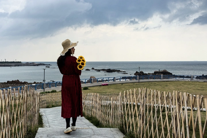 海边拿花的女子