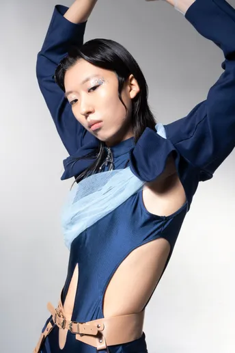 一位穿着蓝色服装的女模特在白色背景上摆姿势