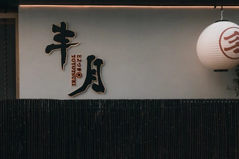 挂在一栋建筑的墙上的一个白色中文招牌