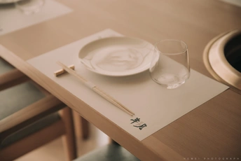 一个木制餐桌配白色盘子和空玻璃杯