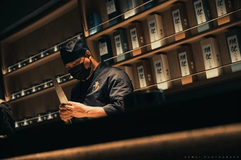 一个坐在图书馆柜台旁的男人正在看他的手机
