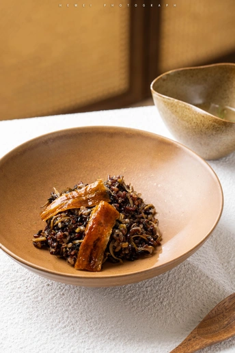 一盘食物放在桌子旁边的一个碗和勺子旁边