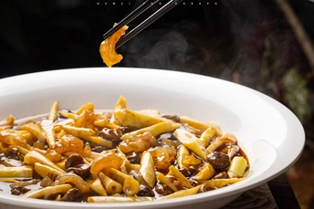 一碗面条 上面有蘑菇和酱汁 用筷子夹取