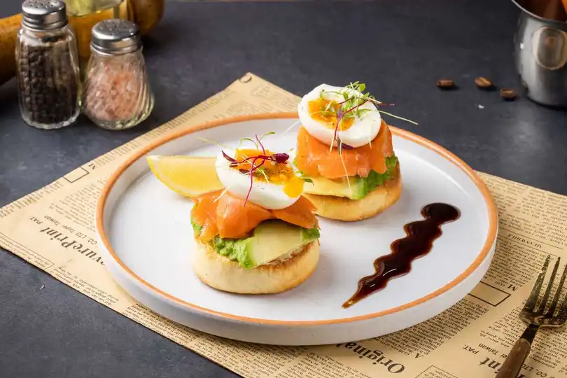 桌子上放着一个带有小三明治的白盘子