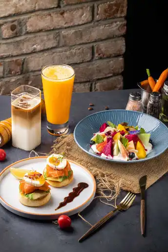 一张带有三明治、沙拉、水果和果汁的餐盘