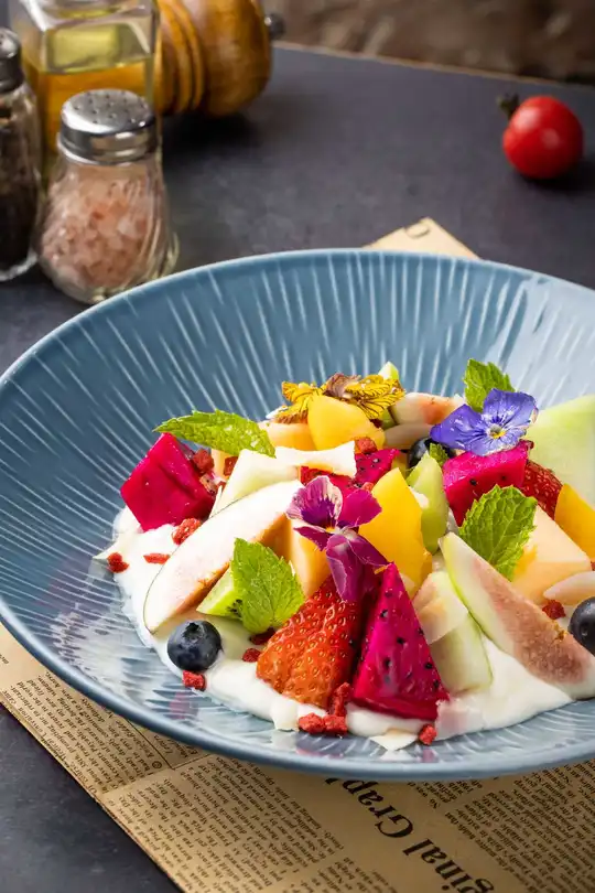 盘中的一道新鲜水果蔬菜沙拉 放在一张蓝色的盘子上。