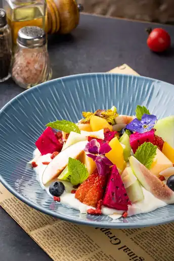 盘中的一道新鲜水果蔬菜沙拉 放在一张蓝色的盘子上。