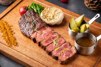 一个带有肉、蔬菜和香料的实木砧板