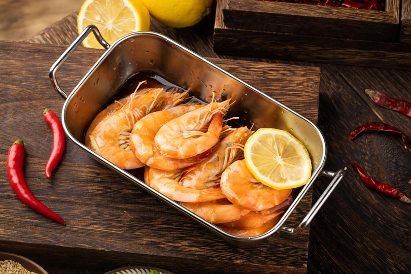 在木桌上用平底锅烹饪虾