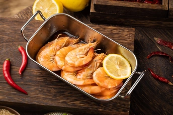 在木桌上用平底锅烹饪虾