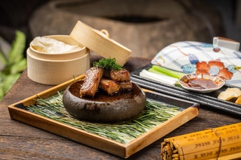 一小盘食物放在木桌上 配有筷子。