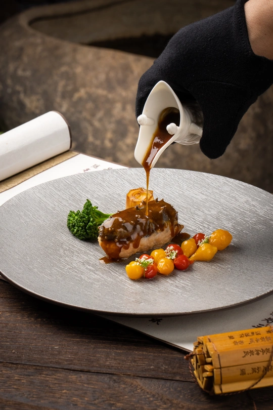 厨师在盘子上淋酱汁