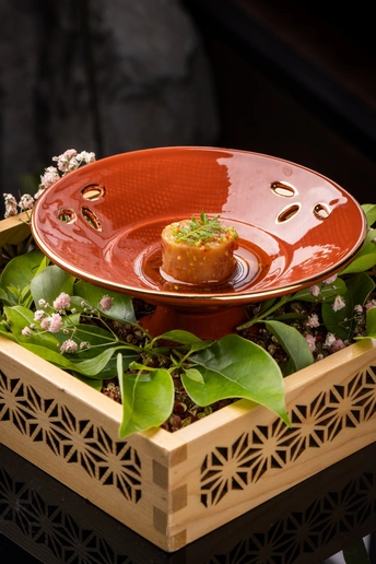 一个小碗装的食物在一个红色的碗里 放在木托盘上。