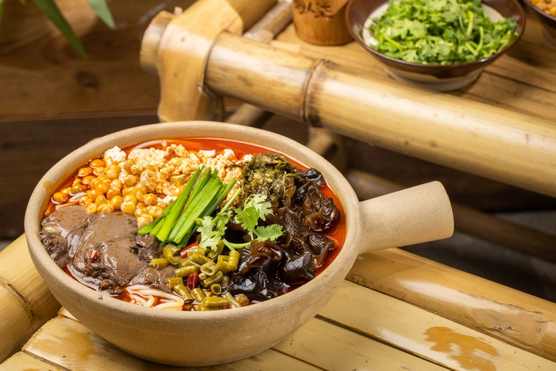 木桌上的汤碗 里面有蔬菜和玉米