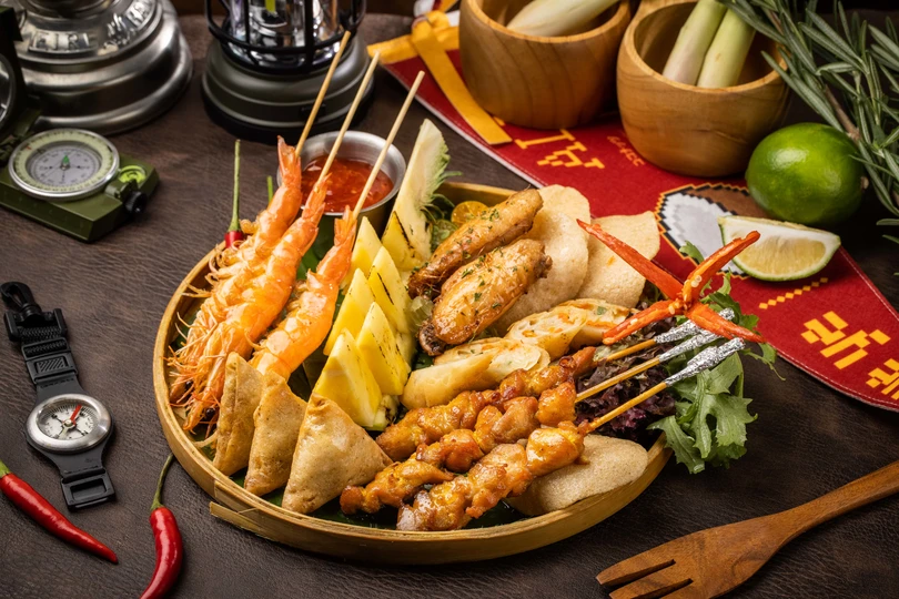 木桌上有一盘虾和蔬菜的食物。