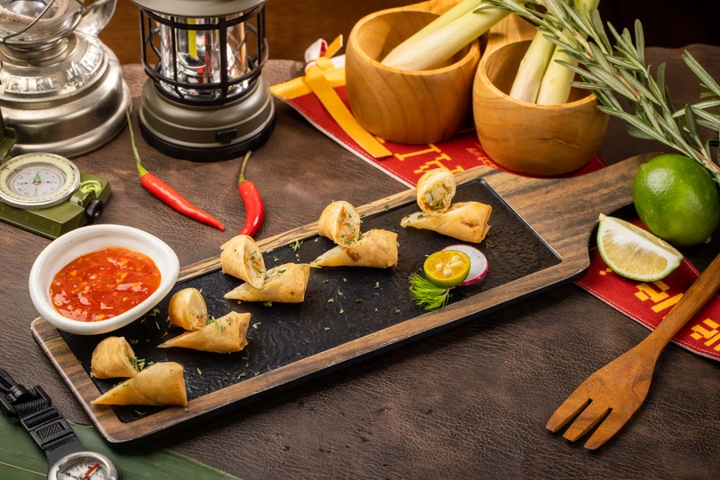 木桌上有食物和酱汁的盘子