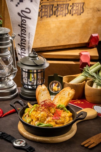 一碗食物放在一张桌子旁边 旁边有一盘蔬菜和一个灯笼。