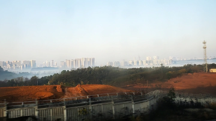 高铁上远眺晨雾中的城市
