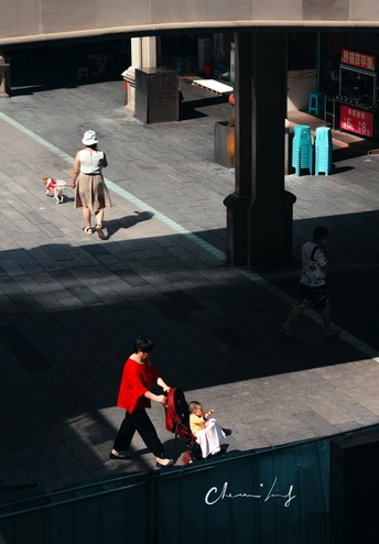 一个人、一个女人和一个孩子带着一只狗在街上走