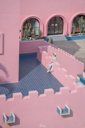 一座粉红色的房子 粉红色的墙壁 楼梯上的一个女子