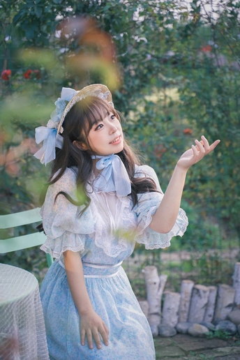 一位穿着蓝色连衣裙的年轻女子在花园里