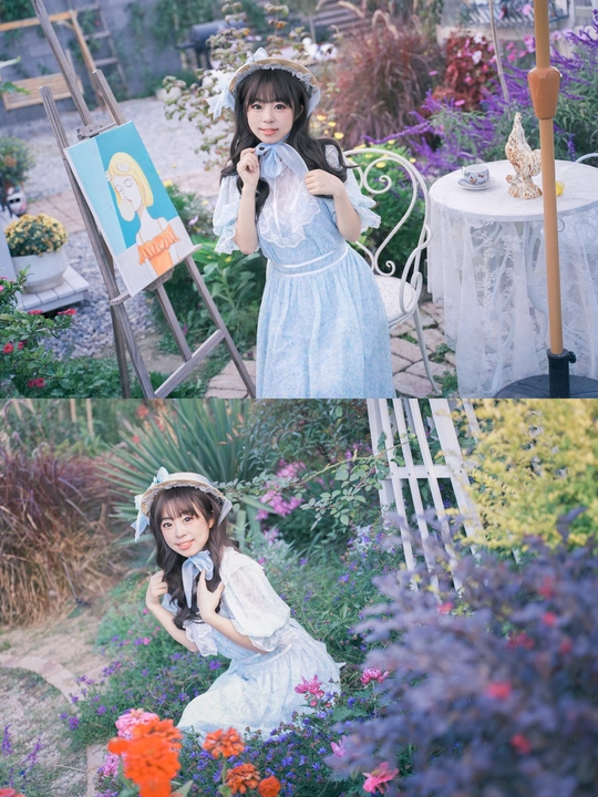 一个小女孩穿着蓝色裙子在花丛中带着一把伞