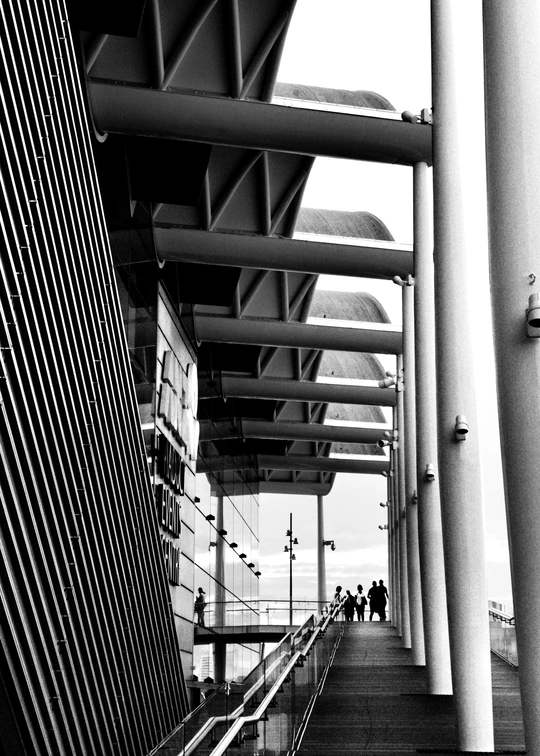 人们在靠近高楼的桥上行走