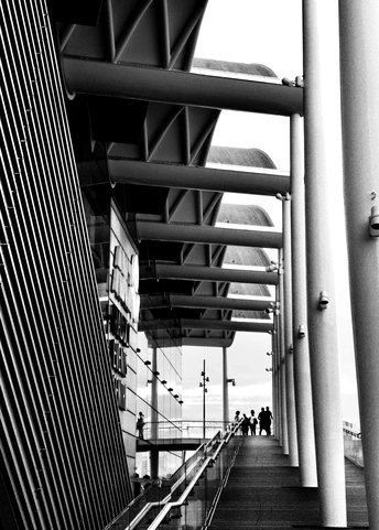 人们在靠近高楼的桥上行走