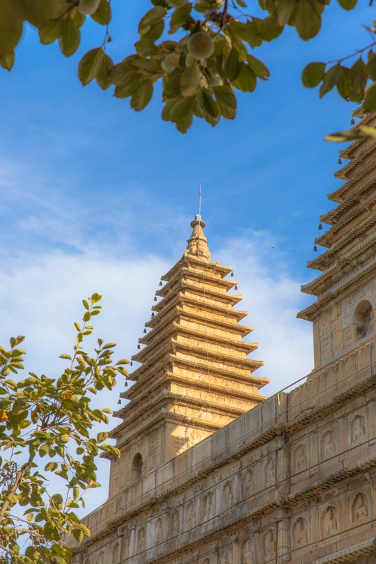 佛教寺庙的金色塔 背景中有树木和天空。