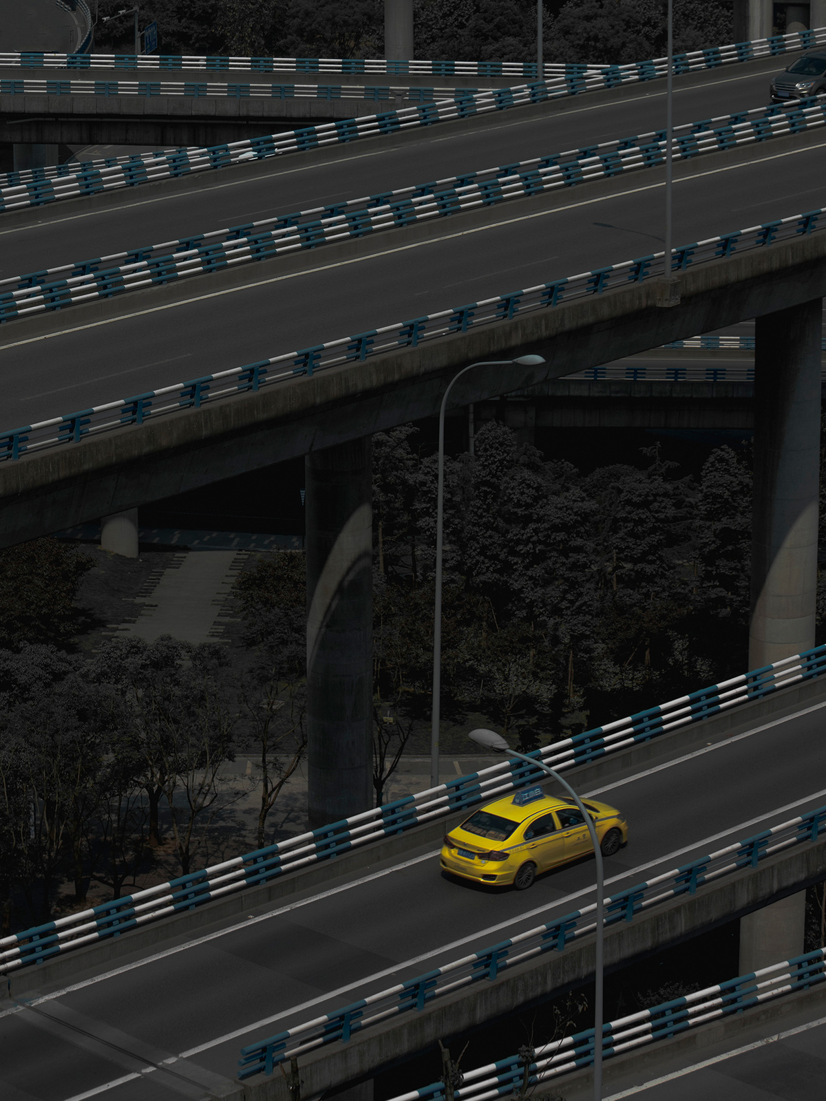 一辆黄色汽车在高速公路下穿桥