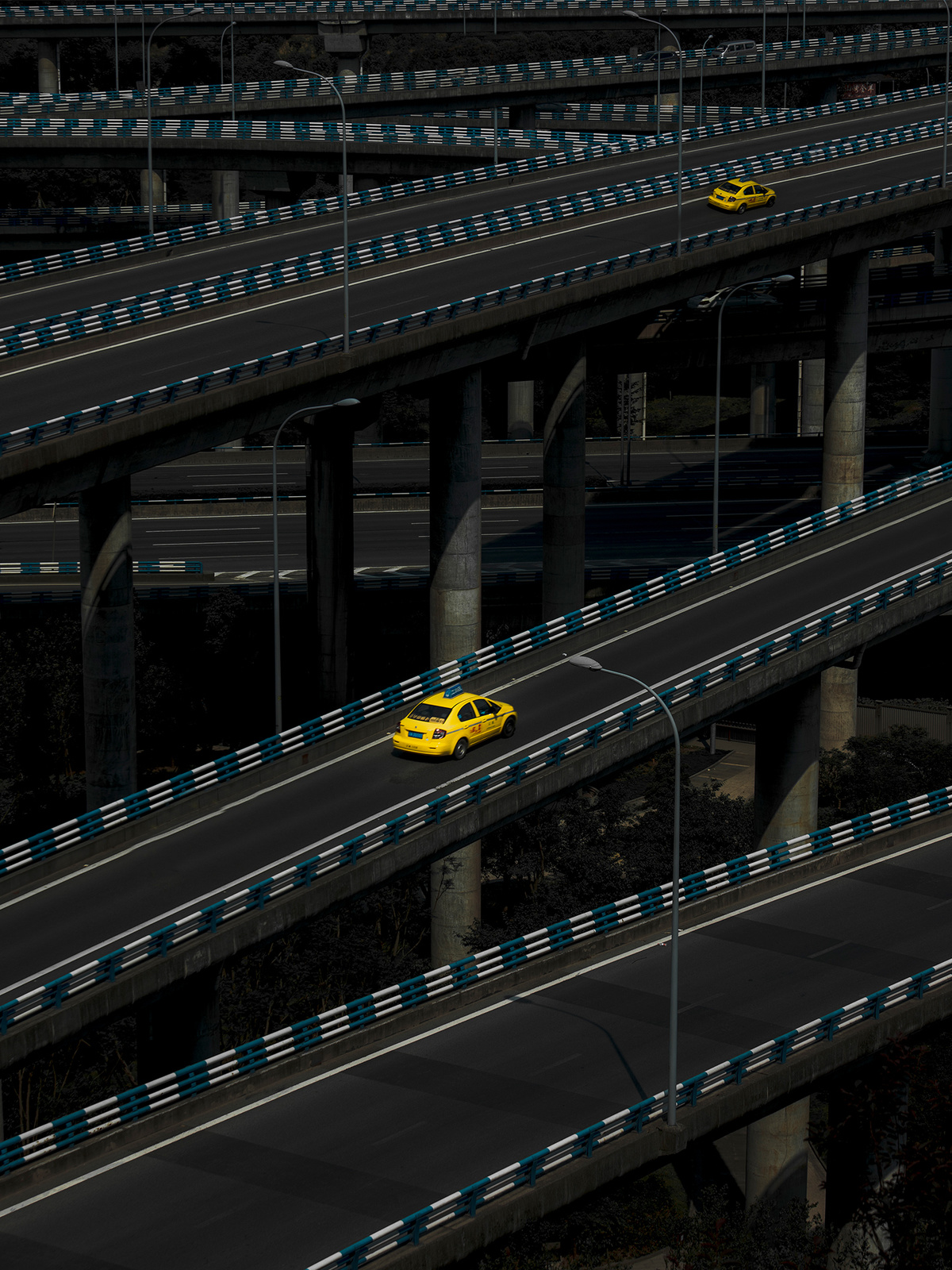 一辆黄色出租车驶过一座天桥 其他车辆在高速公路上行驶。