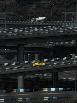 一辆黄色汽车在高速公路上行驶 穿过一座桥。