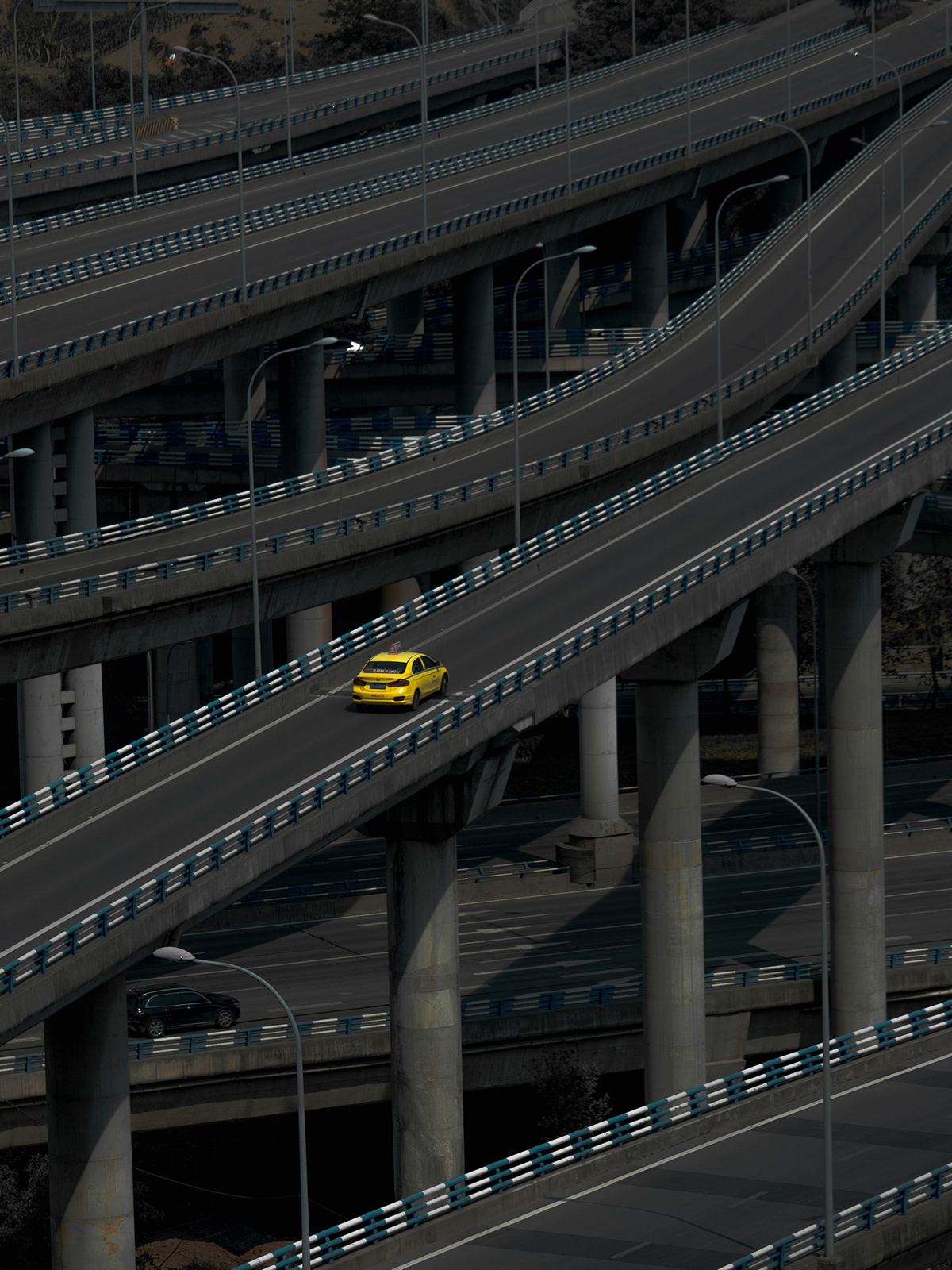 一辆黄色出租车驶过一座天桥 其他车辆在高速公路上行驶。