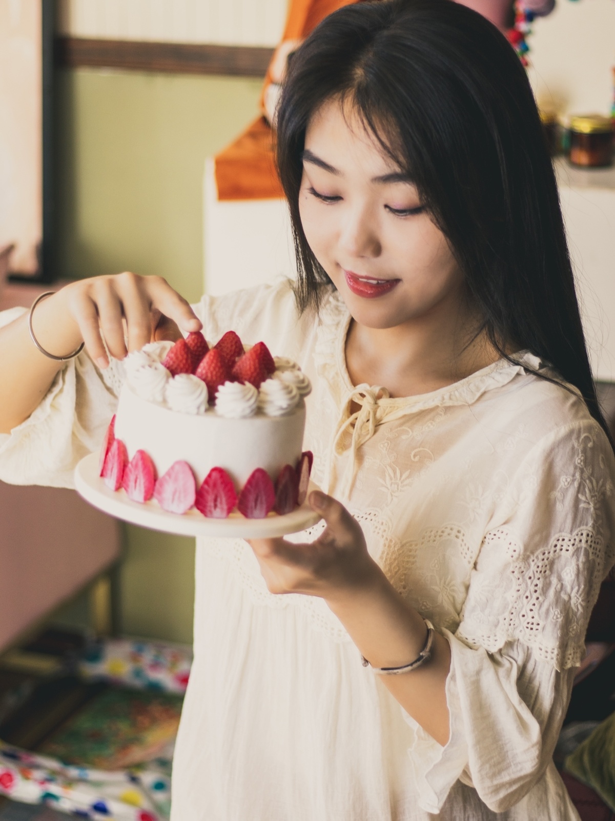 一个年轻女子在一个白色盘子上拿着一个蛋糕