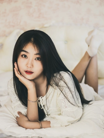 躺在白色床上的年轻女子