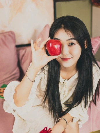 手里拿着一个红苹果的年轻女子