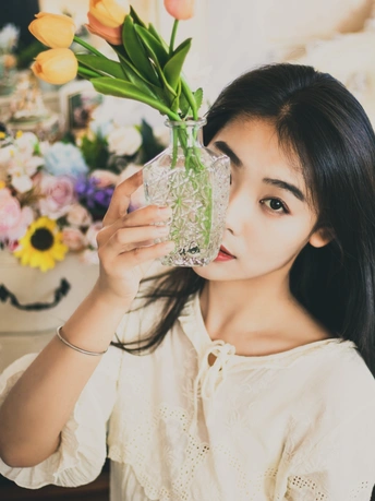 一位年轻女子把一杯清澈的水举在脸前