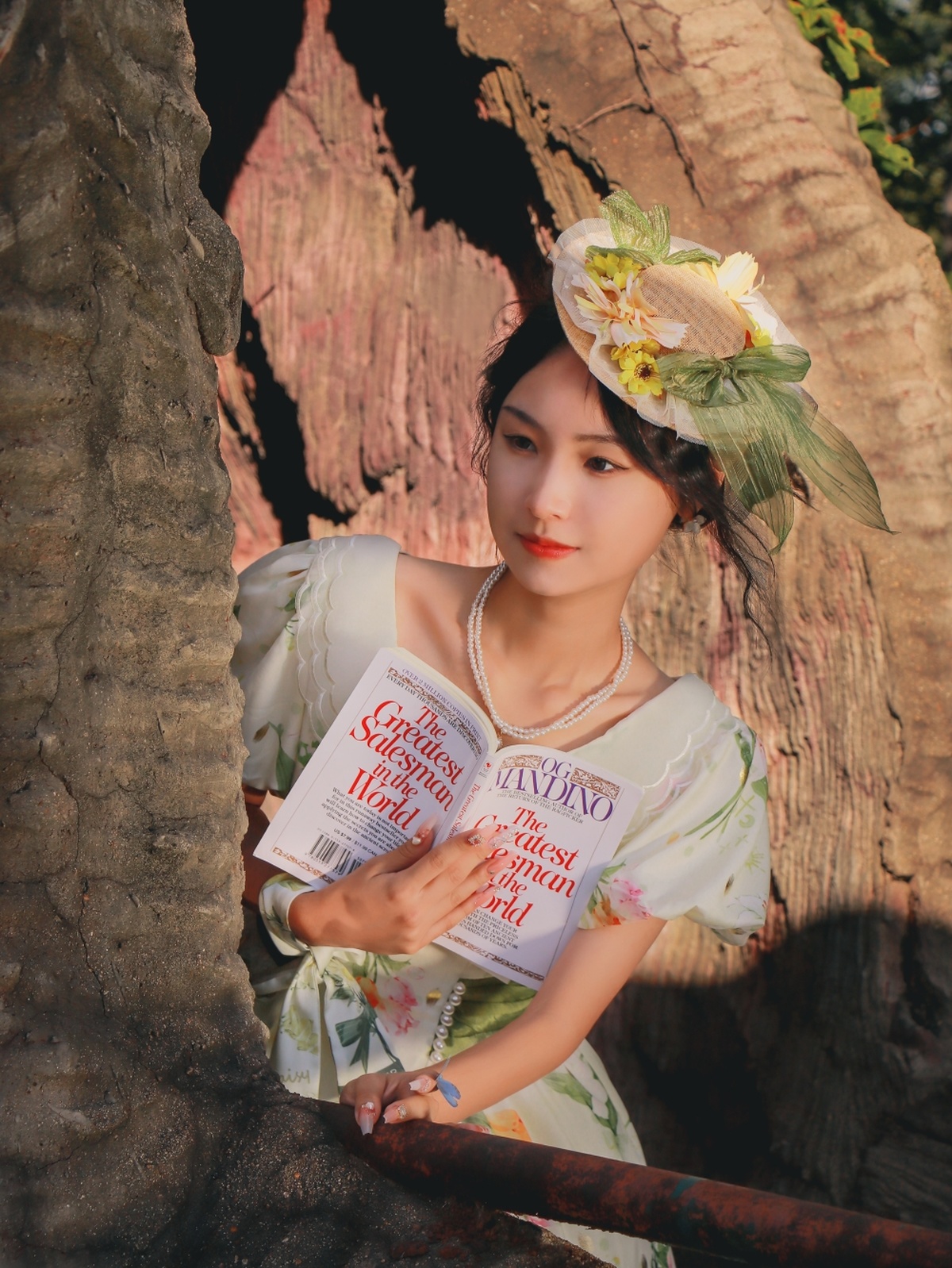 一个穿着带花连衣裙的年轻女子手里拿着一本正在读小说的书