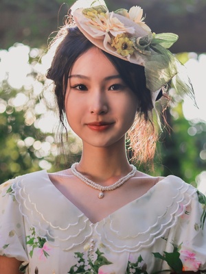 一位年轻女子的画像 她身穿白色连衣裙 头戴带花的花帽