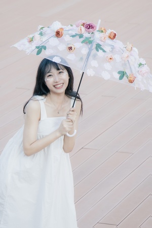 一个穿着白色连衣裙、打着白色雨伞的年轻女子