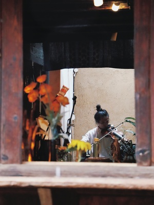 一个坐在桌子前的女人 面前有一个锅和餐厅窗户里的镜子。