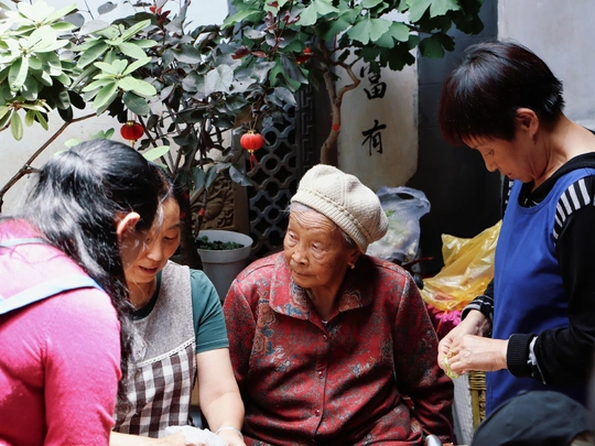 两位老年妇女坐在桌子外面