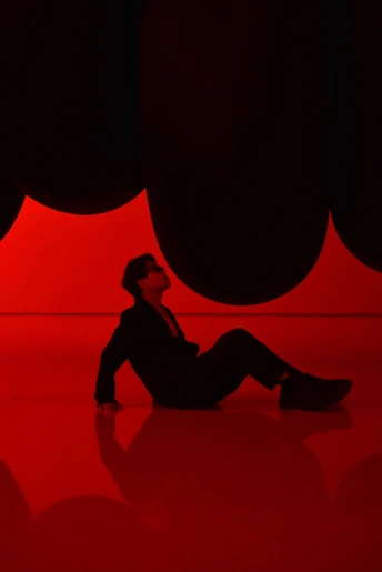 一个坐在地板上的房间里 墙上挂着红色的灯