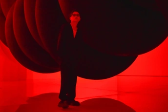 一个站立在红色灯光房间里的巨大男性形象