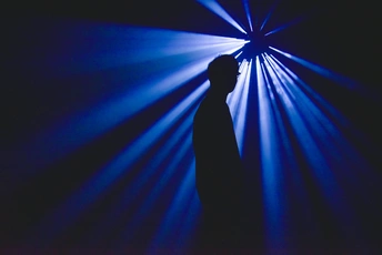 一个站在舞台上的男人的剪影 蓝色的光线照耀在他身上